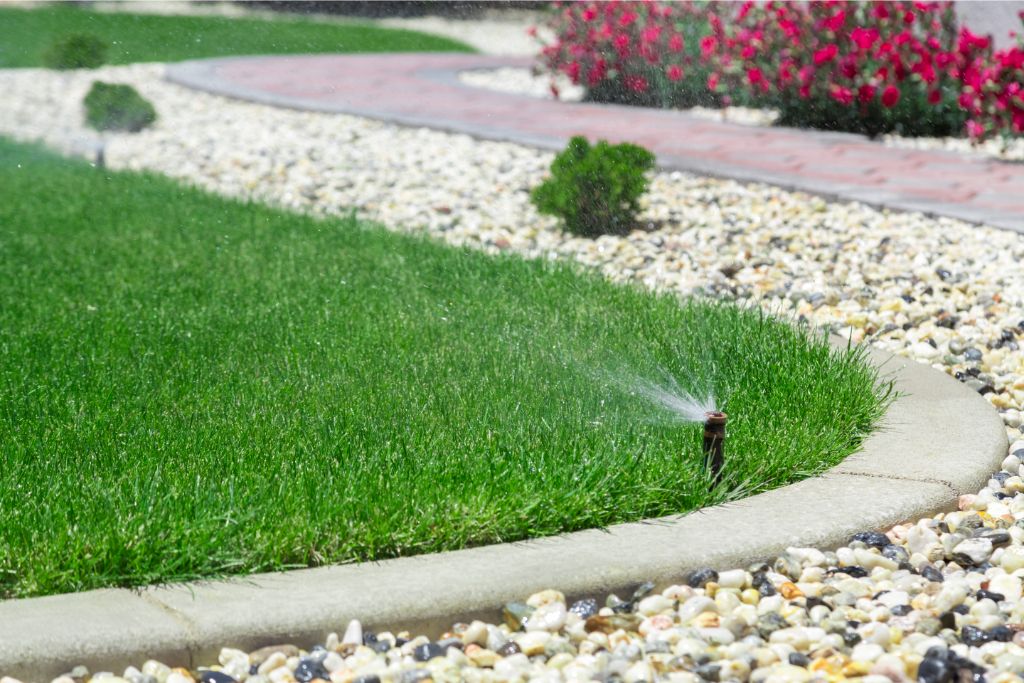 sprinkler sprinkling water to the grass on a garden