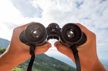 a two hands holding a binocular